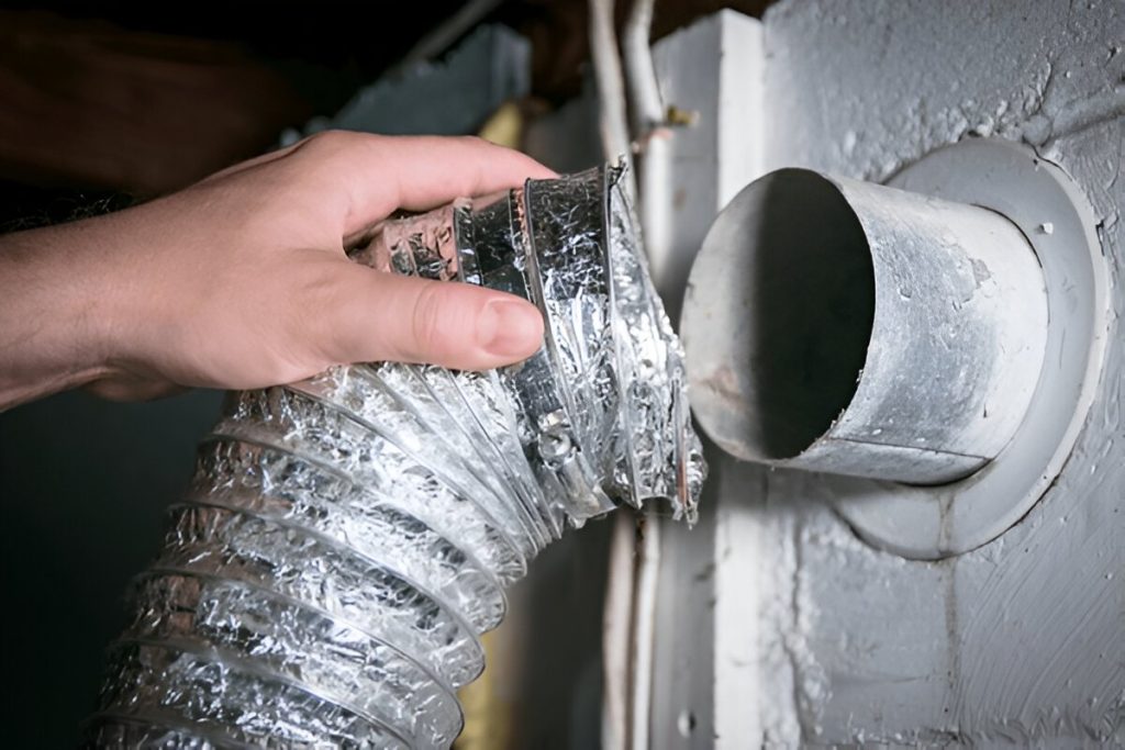 Technician attaching a flexible duct to an air vent in Rochester NY for duct cleaning and maintenance.